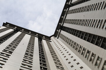 Fototapeta premium low-angle photograph looking directly up at the towering facade of a modern high-rise apartment building