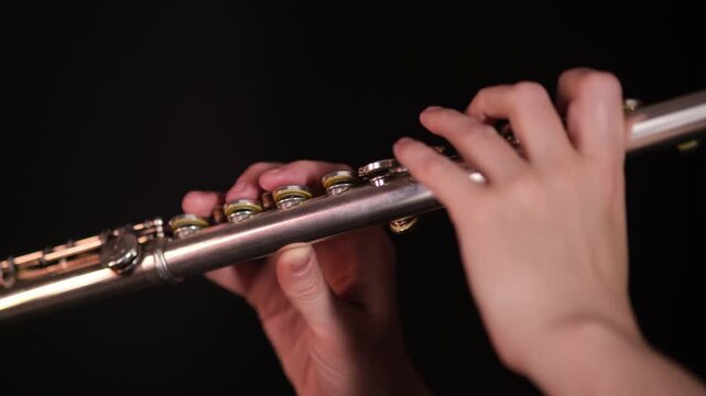 Woman playing silver concert flute. Musician performing classical instrument. Harmony and melody concept. Music school, lessons, performance.