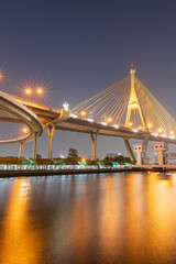 Fototapeta premium A view of a highway interchange and suspension bridges at twilight.