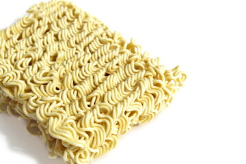 A brick of dry instant pasta lies on a white background.