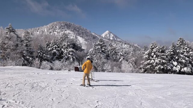 Panning video of skiers on the slope at Yokoteyama resort in Nagano, Japan