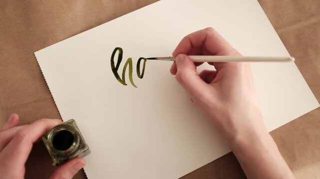Hand-painted watercolor "Happy Easter" calligraphy lettering. Artistic process or finished greeting on white textured paper, featuring spring pastel green color. Ideal for holiday greetings, seasonal 