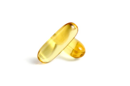 There are several vitamin D capsules on a white background.