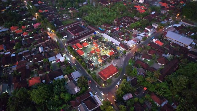 Aerial drone footage of Pura Desa hindu temple, in Singapadu, Sukawati, Gianyar regency, Bali island, Indonesia, with road and houses around