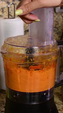 Vertical video of processing red ajies in kitchen blender focused