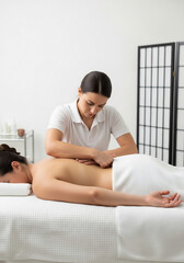マッサージセラピスト は 女性 の 背中 に 集中 し て 施術