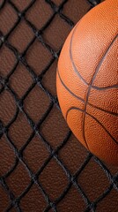 Obraz premium A close-up view of a basketball resting against a net, highlighting texture and color contrast