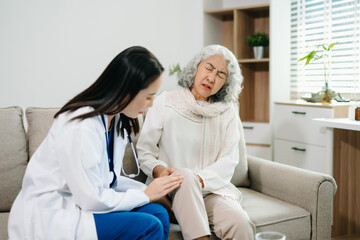 Obraz premium Doctor examining elderly woman with knee pain during home healthcare visit, highlighting arthritis treatment, senior support, medical consultation