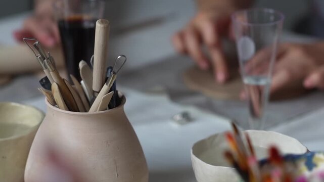 Brushes, stacks and styluses for creativity in a clay pot.  Brushes and a set of tools for modeling and modeling in a clay pot. Creative hobby. 
