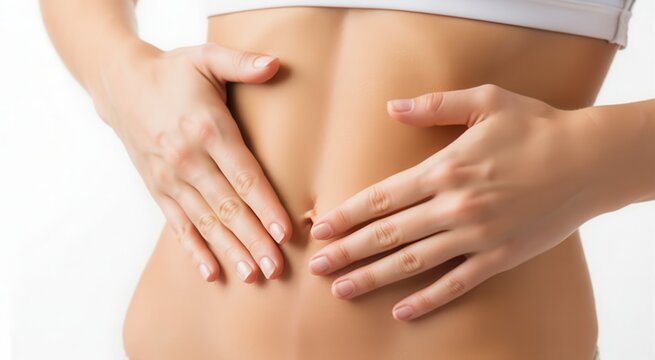 Closeup of a womans slim, toned abdomen with hands gently touching her stomach area, representing health and fitness