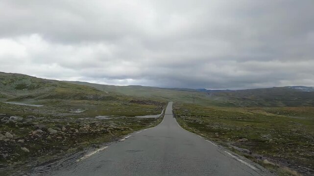 POV shot from a moving vehicle driving along Bj&oslash;rgavegen road in Nalfarbakkane, Nalfarh&oslash;gdi, Norway, following a winding mountain route through Nordic landscape with no people