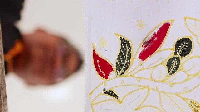 Indonesian artisan drawing traditional batik pattern