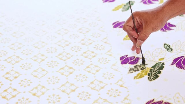 Artisan painting a traditional indonesian batik fabric