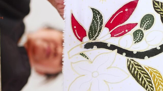 Indonesian artisan proudly showing handmade batik fabric