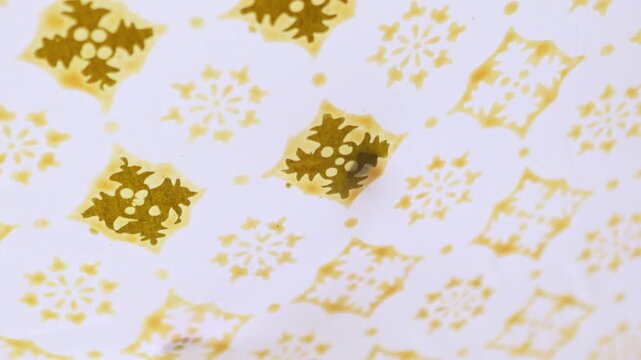 Hand drawing traditional Indonesian batik pattern on cloth