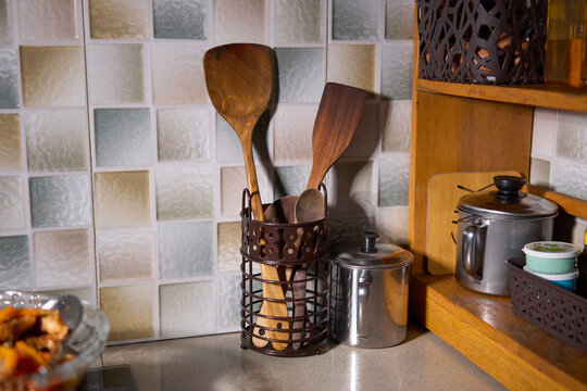 Wooden kitchen utensils and spatulas in a holder on a counter