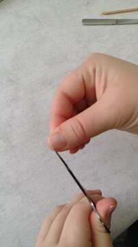 First person POV of cutting a thumbnail with small manicure scissors. Close up shot of personal nail care routine at home, precise grooming process, everyday hygiene and beauty maintenance footage.