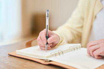 日記をつけるアジア人シニア女性