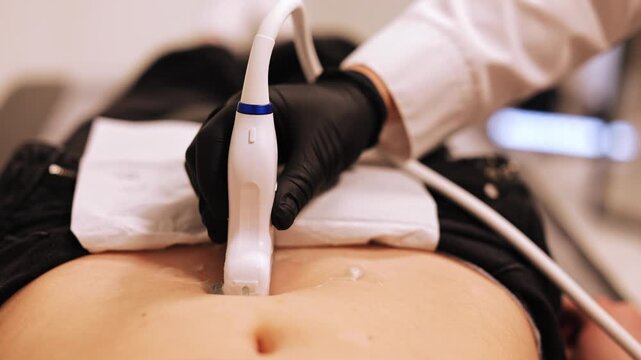 Medical professional performs ultrasound examination on abdomen. Diagnostic imaging provides crucial insights for health and well-being. Procedure offers peace of mind and essential medical care.