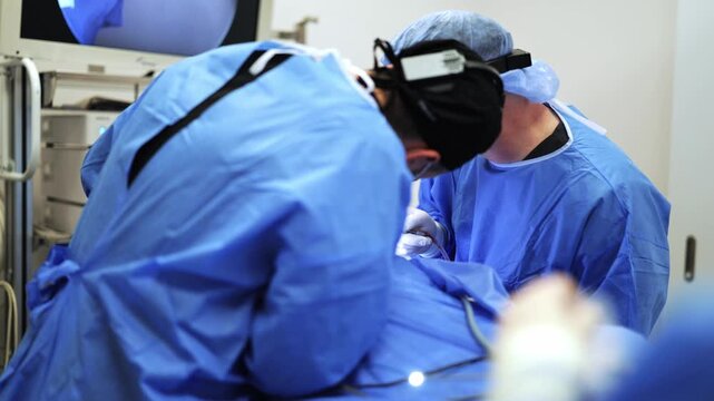 Surgeons display intense focus and dedicated expertise during a critical operation. Sterile environment, advanced medical technology, and precision aim for positive health outcomes with utmost care.
