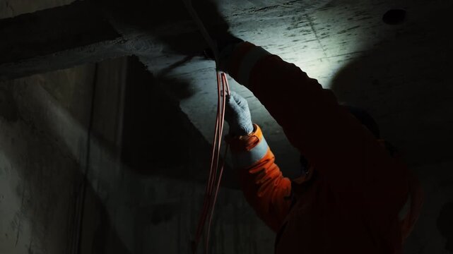 Worker installing internet cables under ceiling