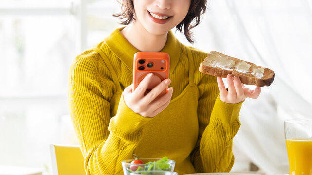 自然光の部屋で朝食を楽しむ若い女性のライフスタイル, Young Japanese woman enjoying breakfast in a sunlit room, lifestyle concept
