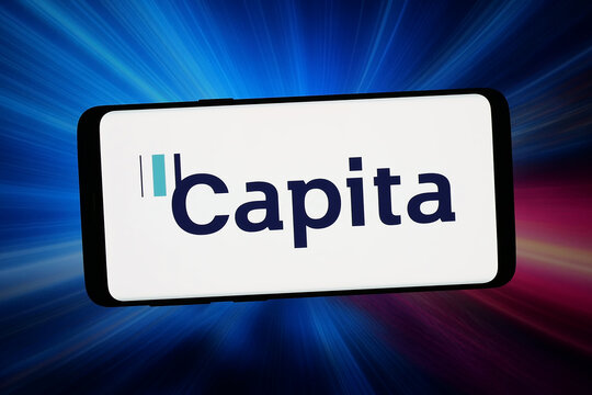 Stuttgart, Germany - 02-19-2026: In this photo illustration, the logo of British outsourcing company Capita plc is displayed on a smartphone in front of abstract background on computer screen.