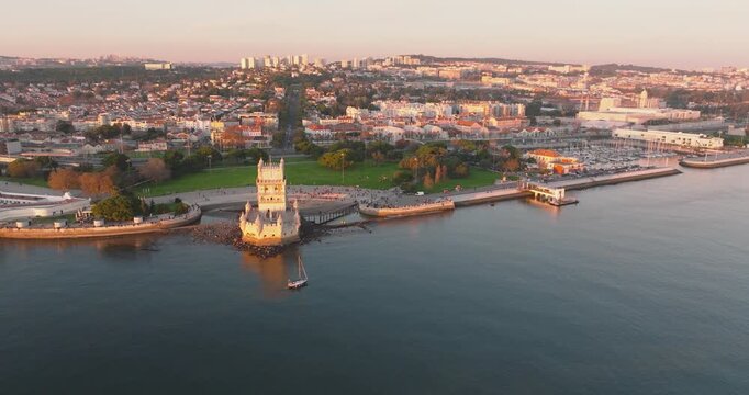 Bel&eacute;m Tower and Lisbon riverfront on Tagus River at golden hour, aerial drone shot, Portugal