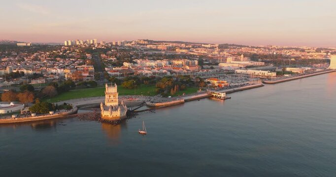 Bel&eacute;m Tower with Lisbon cityscape and Tagus River at golden hour, aerial drone shot, Portugal