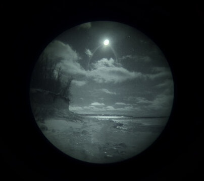 Authentic Night Vision View of a Coastal Landscape at Night Through a Real Gen 3 Image Intensifier Tube with Grain