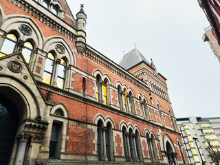 Fototapeta premium Historic red brick Minshull Street Crown Court building in Manchester with arched windows and ornate stone facade