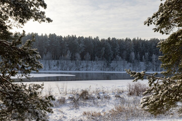 a wide river that is almost frozen in winter , a part of the river that is not frozen after severe frosts, the rest of the river is covered with ice and fresh snow