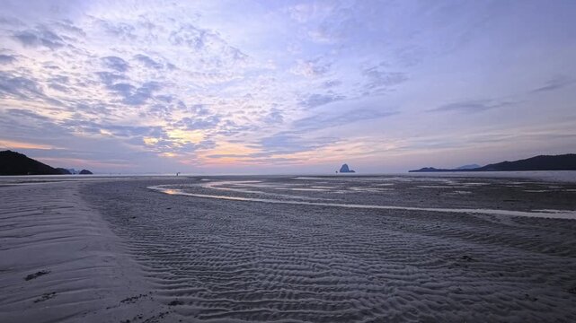 Wide intertidal sand flats with textured ripples under pastel dusk sky in Thailand