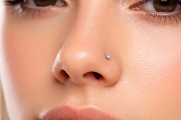 Fototapeta premium Woman with a diamond nose ring close-up shot. Body piercing fashion accessory. Facial jewelry for style and expression.
