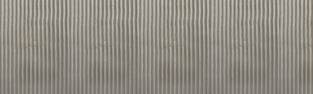 Wide Panoramic View of Brownish Grey Corrugated Concrete Surface with Vertical Linear Pattern