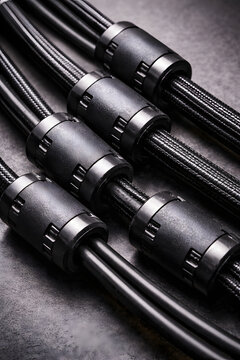Close up of multiple shielded cables with ferrite components, illustrating electromagnetic interference control in RF and defense electronics