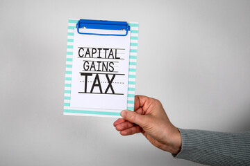 Capital Gains Tax Text On Clipboard Held By Hand Finance Concept