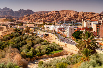Obraz premium Town Wadi Musa with mountains and palm trees. View from above streets in the Jordanian tourist resort of Petra.