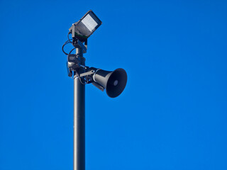 A warning system including a loudspeaker, a floodlight and a CCTV camera on a pole