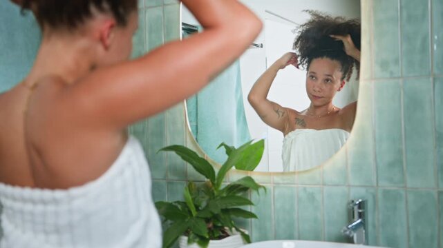 Young Black Woman with Natural Hair Styling Her Curly Locks in the Bathroom Mirror During Morning Routine