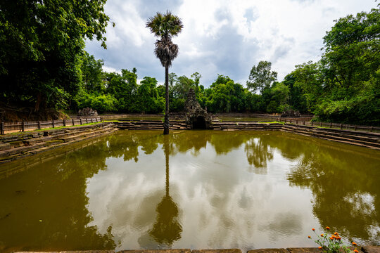 Ancient Neak Pean temple pool surrounded by lush forest