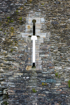 Narrow window arrow slit on an ancient Norman era castle.