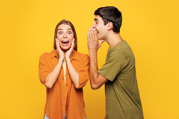 Young couple two friends family man woman wear shirt casual clothes together whispering gossip...