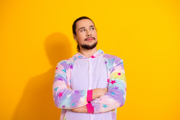 Young man in pastel unicorn pajamas with star print poses against bright yellow background