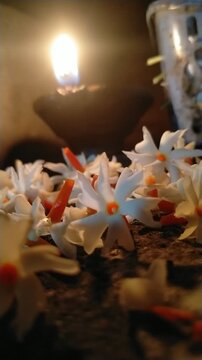 Traditional Oil Lamp with Night Jasmine Flowers Burning in Dark Spiritual Background	