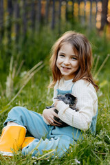 Fototapeta premium Young girl gently cuddles a fluffy bunny in her arms.