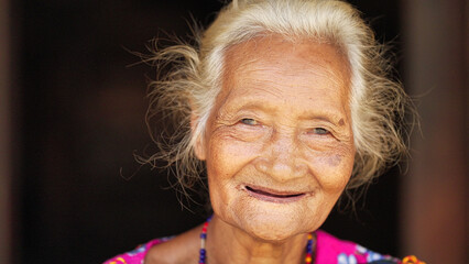 elderly indonesian woman smiling, authentic people portrait on flores island, southeast asia, winkled face and grey hair