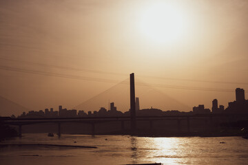 The silhouettes of city skyline surrounded by the sea under the sunlight during the sunset in Chongqing, China