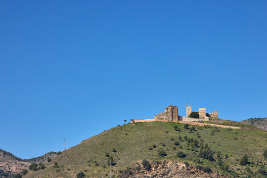 Castillo de zalia ruins on a green hill under blue sky