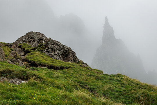 Misty rock formations and grassy slopes at the Old Man of Storr.